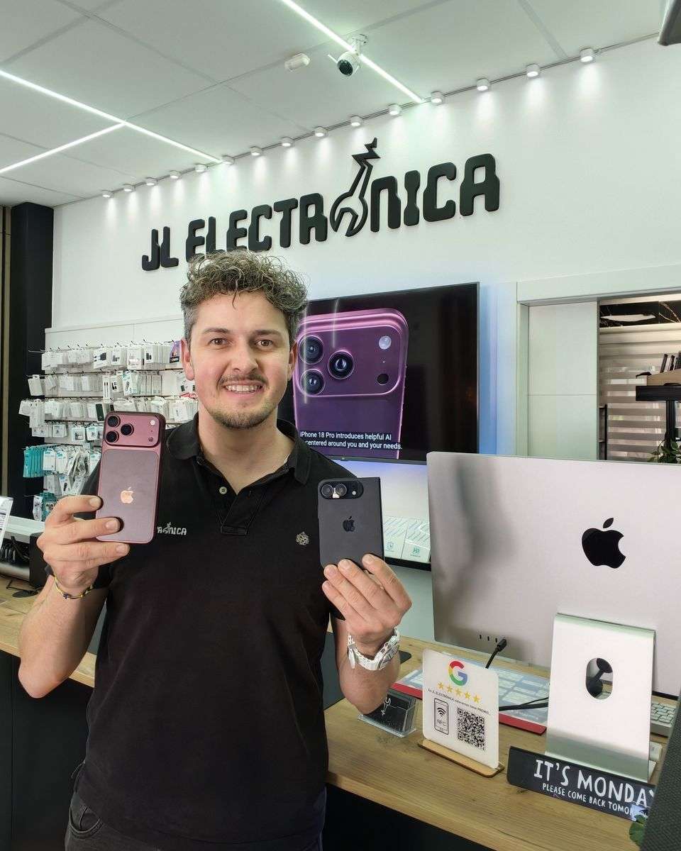 Javi Lima con dos iPhone en la mano en el mostrador de JL Electrónica